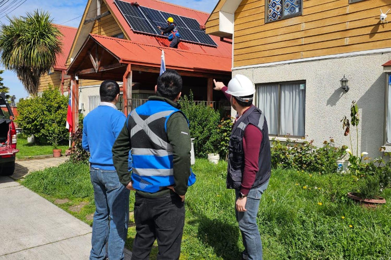 Equipo revisando desde el suelo una instalacion fotovoltaica montada en el techo de una vivienda